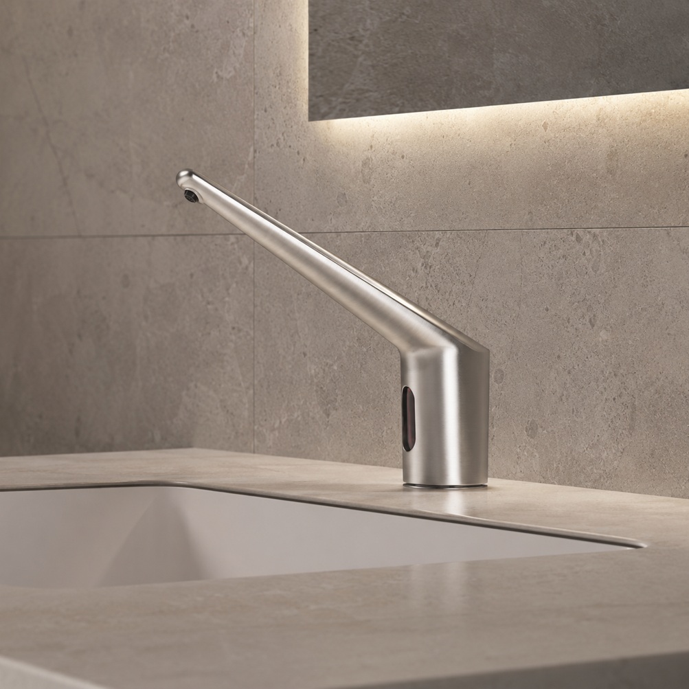 Brushed nickel long-spout touchless faucet model installed on a stone bathroom vanity with integrated sink and modern backlit mirror
